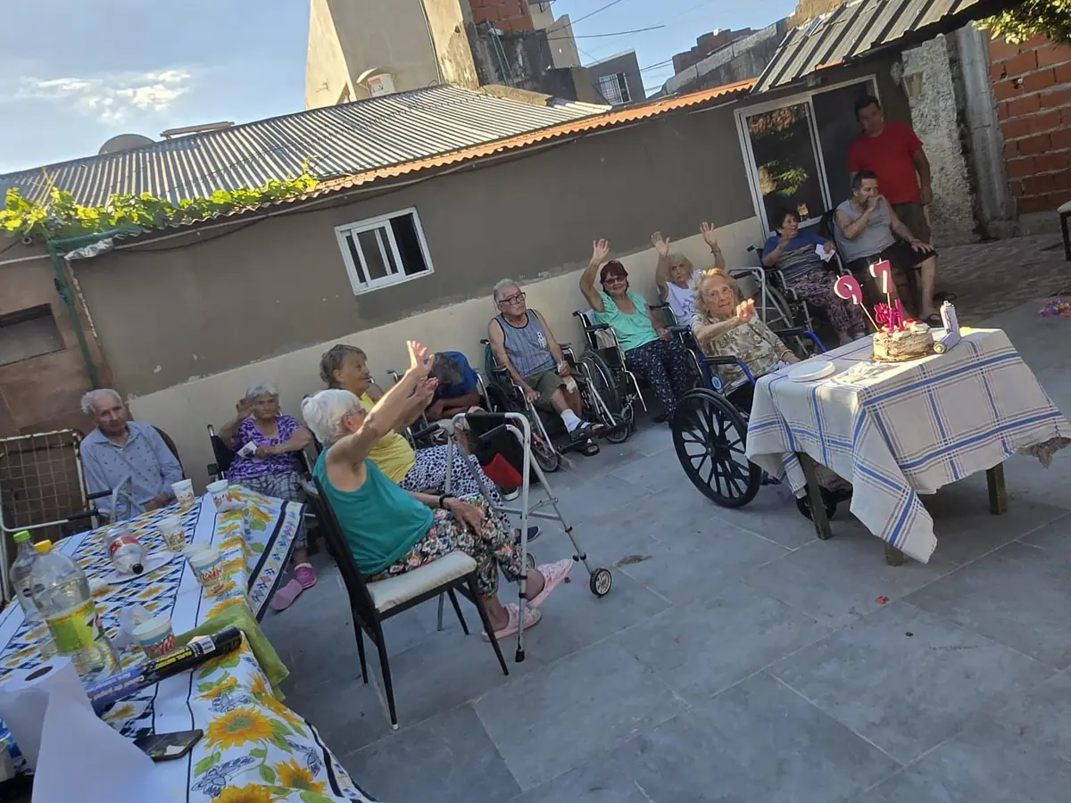 Residentes de Hogar Jequina compartiendo un festejo en el patio